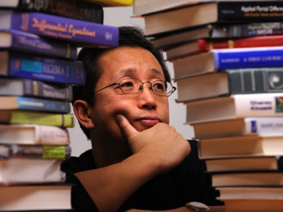 Hongkai Zhao looking thoughtful between stacks of books