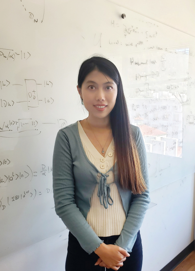 Di Fang standing in front of white board of equations